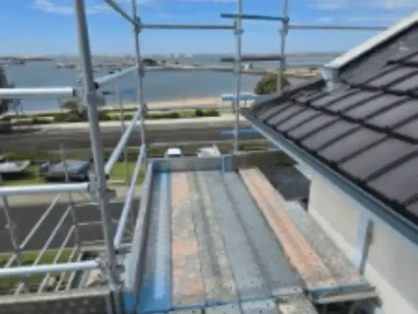 Scaffold platform along a roof edge overlooking the water during a Bunbury re-roofing job