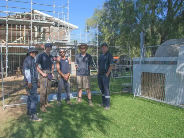 Bay Scaffold & Fence Hire team beside temporary site fencing at a client build