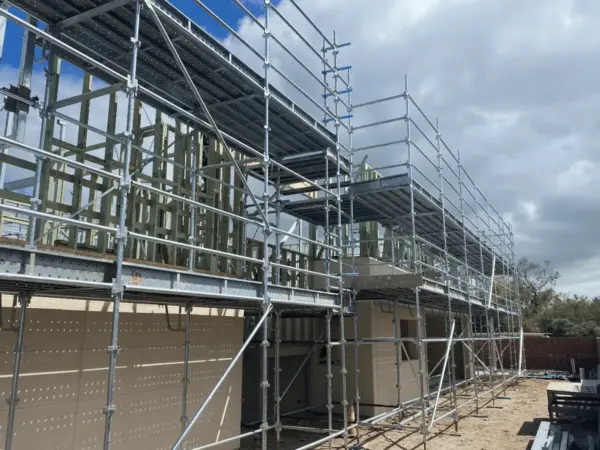 Steel-framed second storey extension wrapped in scaffold during a Margaret River build