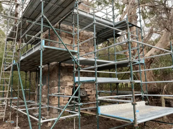 Scaffold tower erected over a stone retaining wall on a bushland Margaret River site