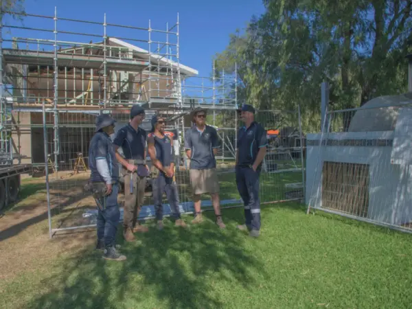 Bay Scaffold & Fence Hire team beside temporary site fencing at a client build
