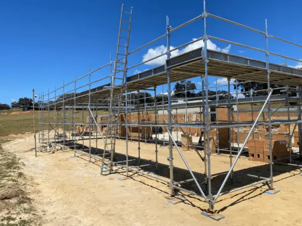 Large scaffold structure over a new build with brick pallets on site in Yallingup
